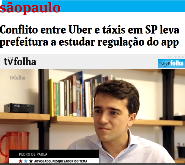 PrintScreen do reportagem da Folha de São Paulo. No título, lê-se: Conflito entre Uber e táxis em SP leva prefeitura estudar regulação do app. Em baixo, há uma imagem do Pedro. Ele é branco, cabelos curtos castanhos e está com os lábios fechados. Usa uma camisa social branca, e está atrás de uma estante de livros.