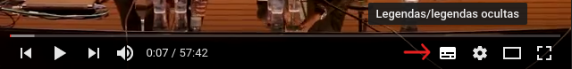 Imagem do rodapé do YouTube, mostrando os botões, da esquerda para a direita: voltar, play/pausar, avançar, volume, minutos do vídeo, legendas, configurações, modo teatro e modo tela cheia. Há uma seta vermelha indicando para o botão de "legendas".