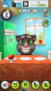 Print de tela do jogo Meu Talking Tom mostrando uma tela do jogo em que o personagem se encontra na cozinha e acima da tela um anúncio do aplicativo Uber, com logotipo da marca e os textos "Uber", "Grátis" e "Instalar".