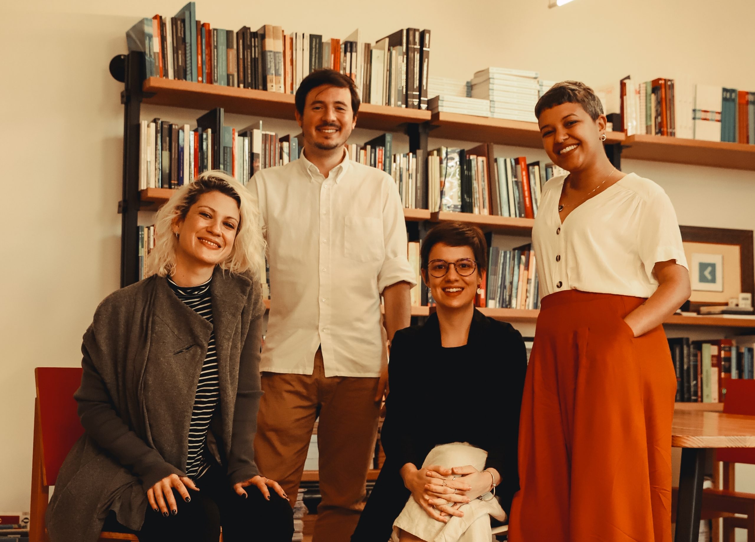 Na foto constam, da esquerda para a direita, Mariana Valente (diretora associada), mulher branca de cabelos loiros platinados, com um casaco cinza. Está sentada em uma cadeira vermelha; Francisco Brito Cruz (diretor executivo), homem branco de cabelos pretos e bigode. Aparece na imagem em pé usando uma blusa branca; Heloisa Massaro (diretora), mulher branca de cabelos pretos e óculos de grau. Aparece sentada com um blazer preto e calça branca; e Fernanda Martins (diretora), mulher negra de cabelos curtos e grisalhos. Veste uma blusa branca e uma calça laranja. Ao fundo, há uma estante de livros. (Foto de Bianca Moreira/InternetLab)